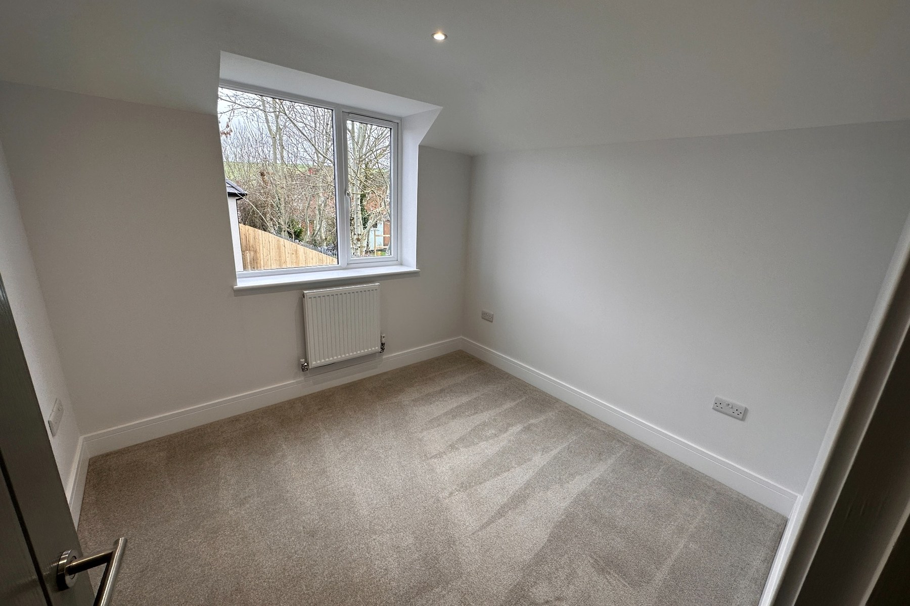 Bedroom with dormer window and radiator.