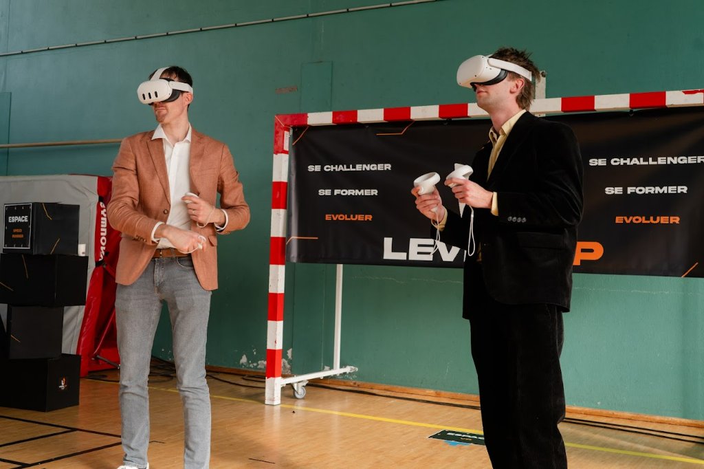 Deux hommes portant des casques de réalité virtuelle dans un gymnase lors de LEVEL UP 2025