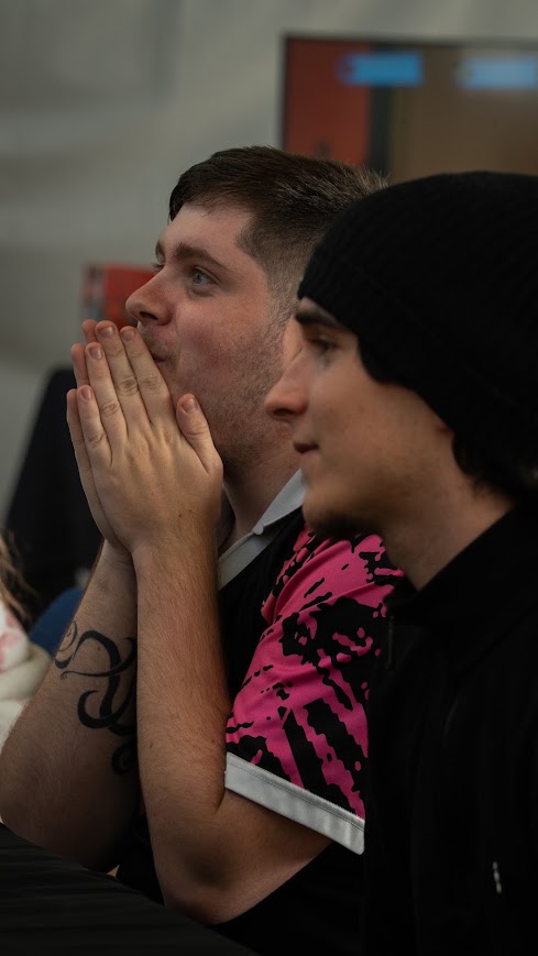 Gros plan sur deux jeunes hommes concentrés lors d'une session de jeu vidéo intense à LEVEL UP.