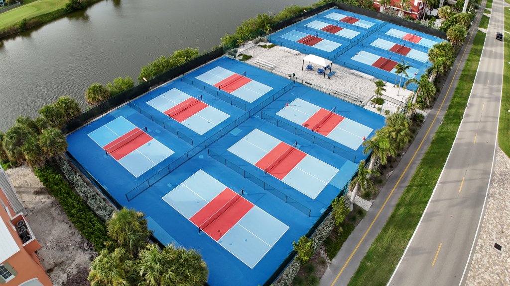 Aerial view of pickleball and tennis courts surrounded by palm trees on Sanibel Island