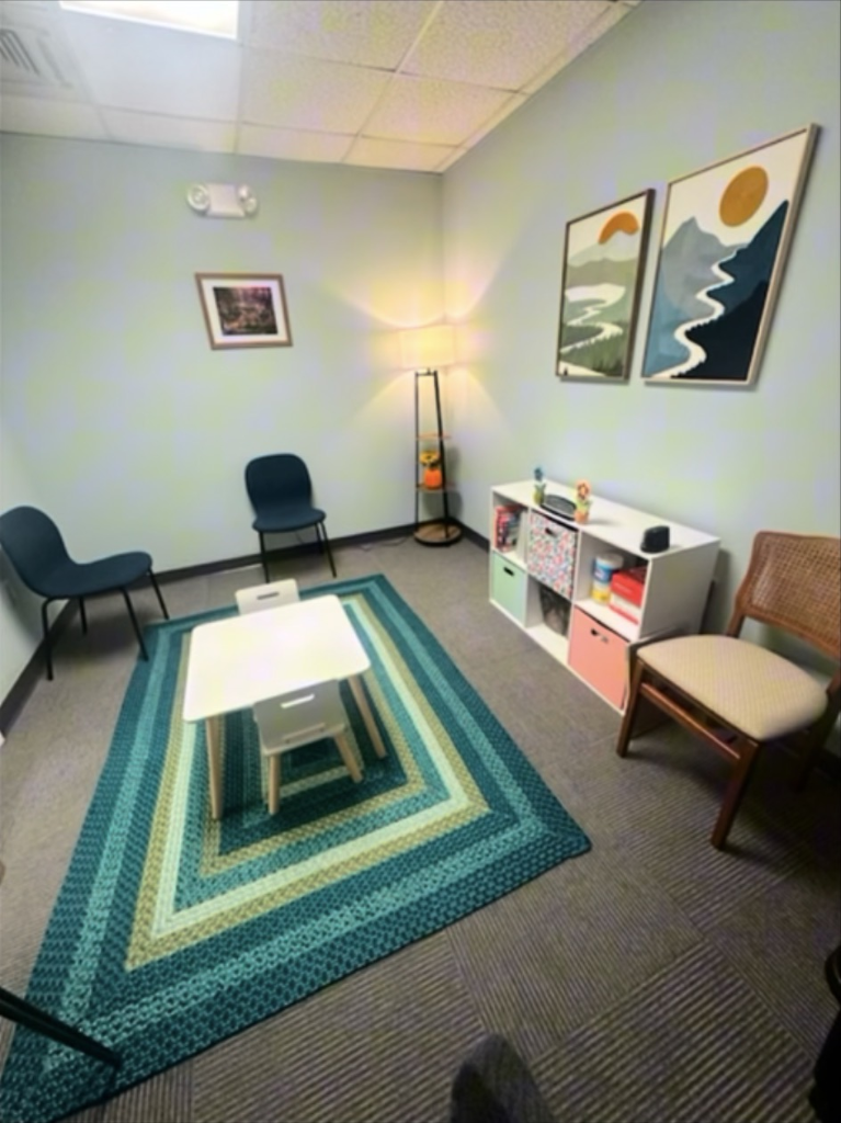 Child-friendly assessment room with colorful rug and small table