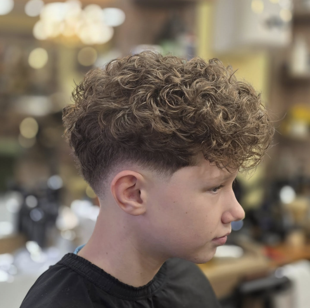 Curly textured top with clean skin fade — side profile at VIP Cut Barber