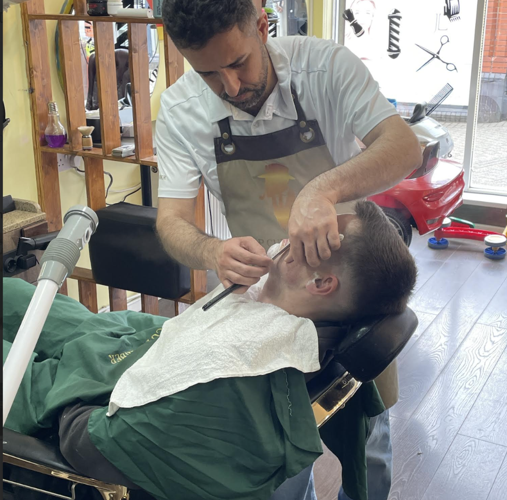 Barber performing a straight razor shave on a client at VIP Cut Barber