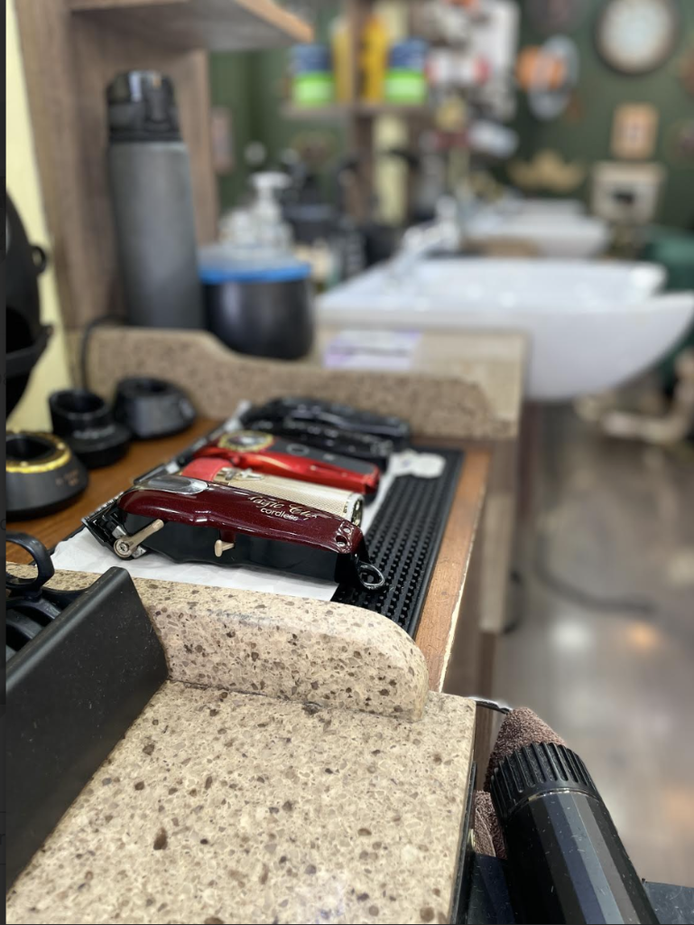 Close-up of professional barber clippers and tools on the workstation counter at VIP Cut Barber