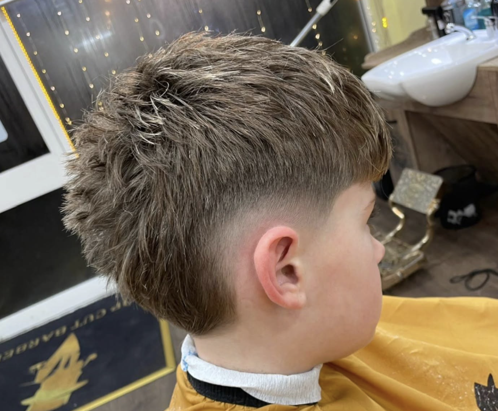 Kids skin fade in yellow cape at VIP Cut Barber
