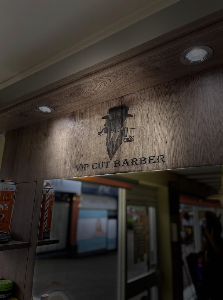 VIP Cut Barber branded wooden signage with fedora gentleman logo and spotlight detail