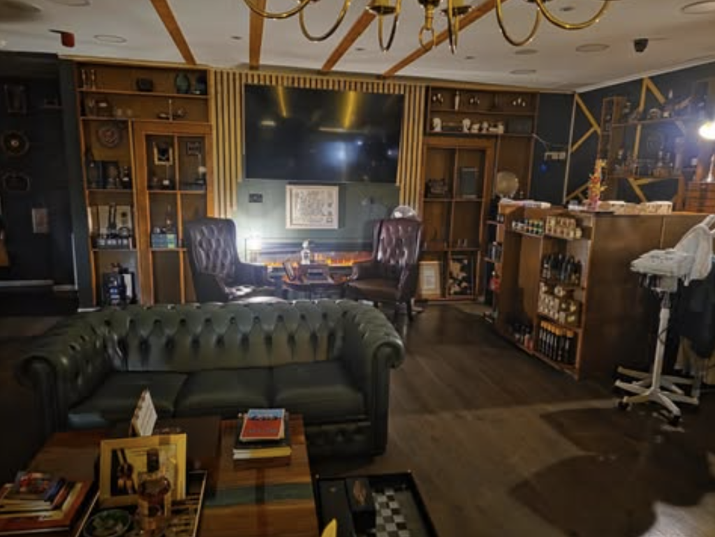 VIP Cut Barber lounge with green leather chesterfield sofa, armchairs and gold chandelier in Newton Mearns