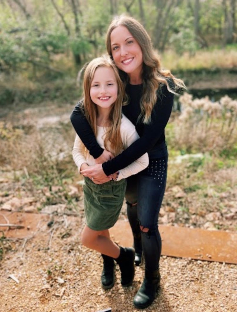 Ashlee and her daughter Izabella, founders of Apothecary of Eden, embracing outdoors