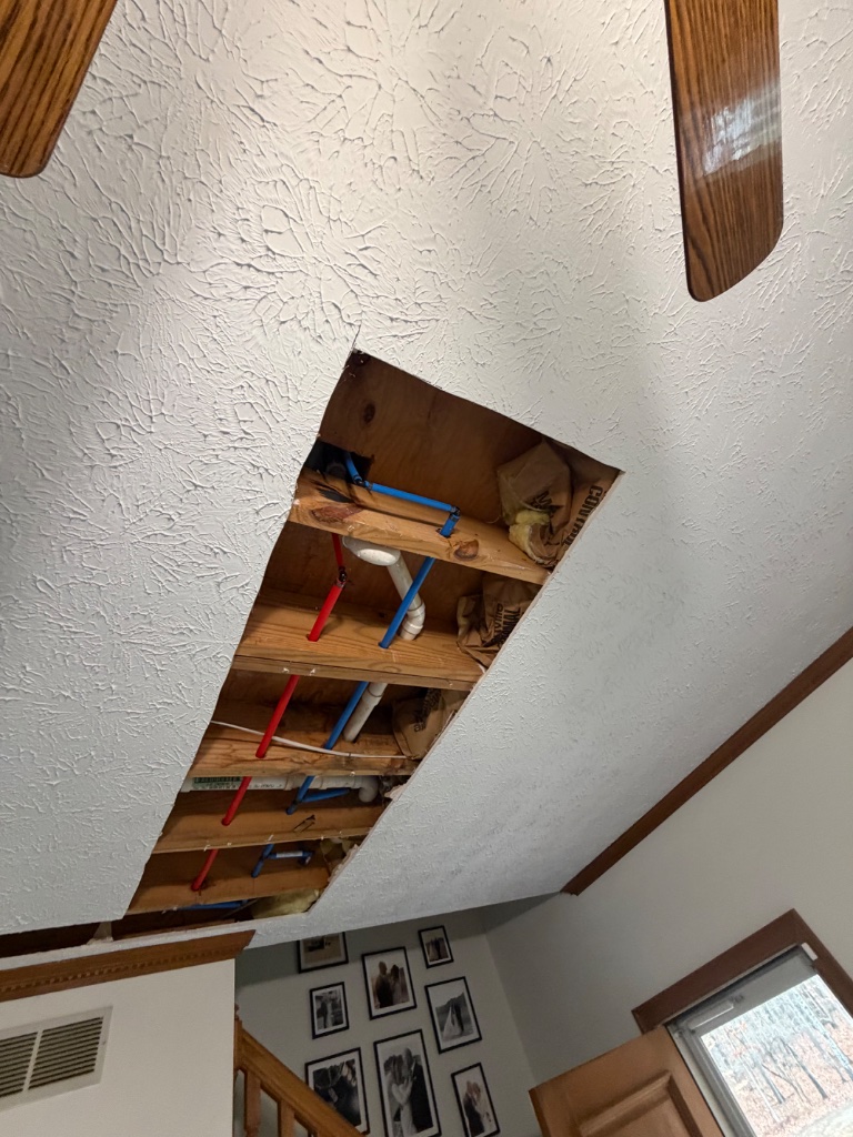 Ceiling access opened to route new water lines properly