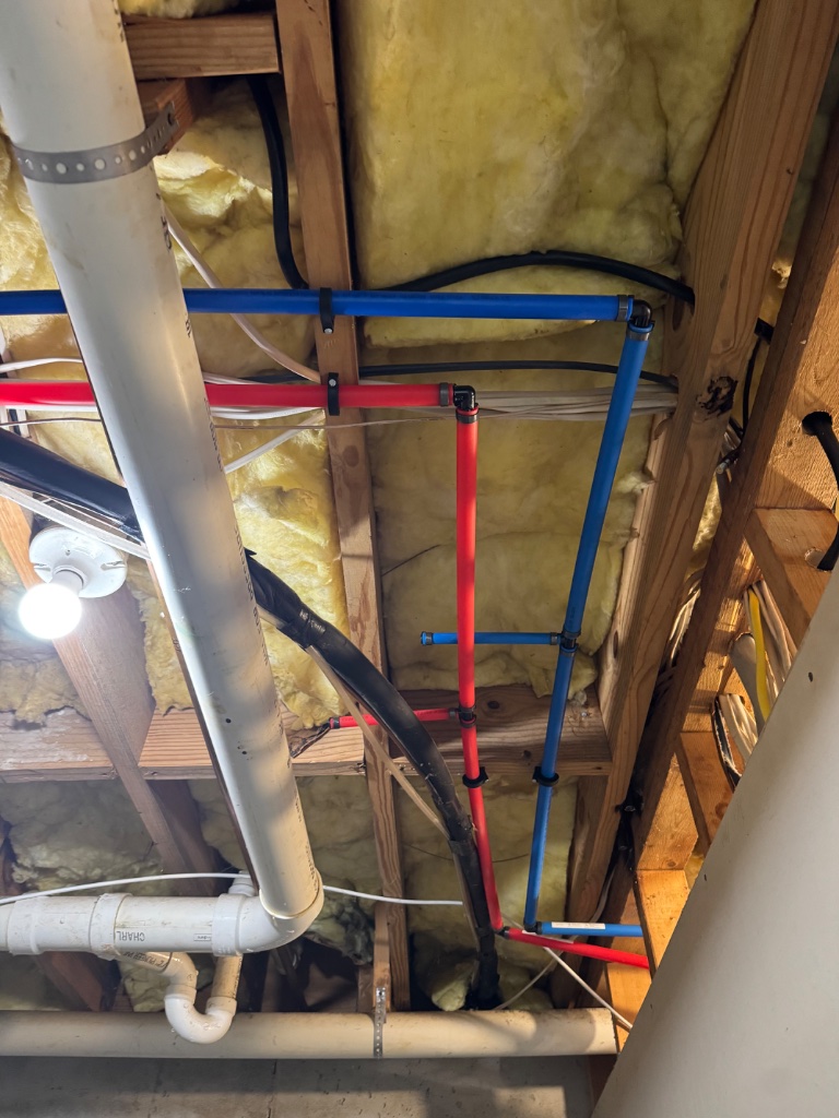 Hot and cold PEX-B lines secured through the joists