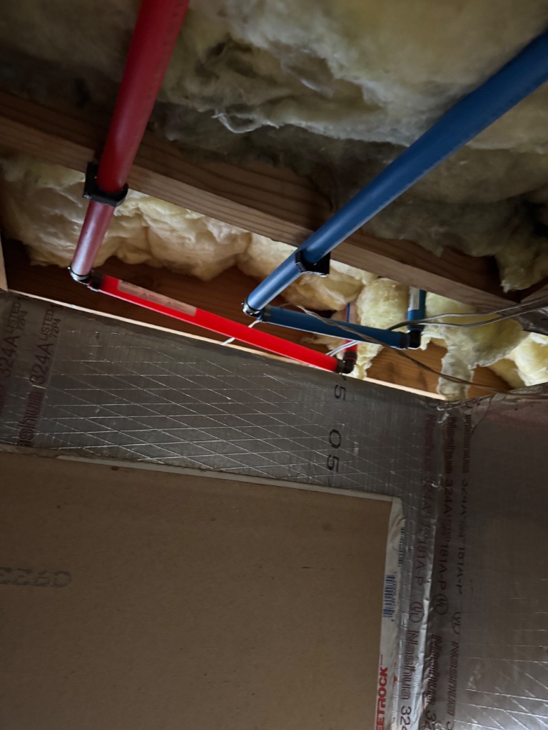 Insulated hot water line passing through the joist bay