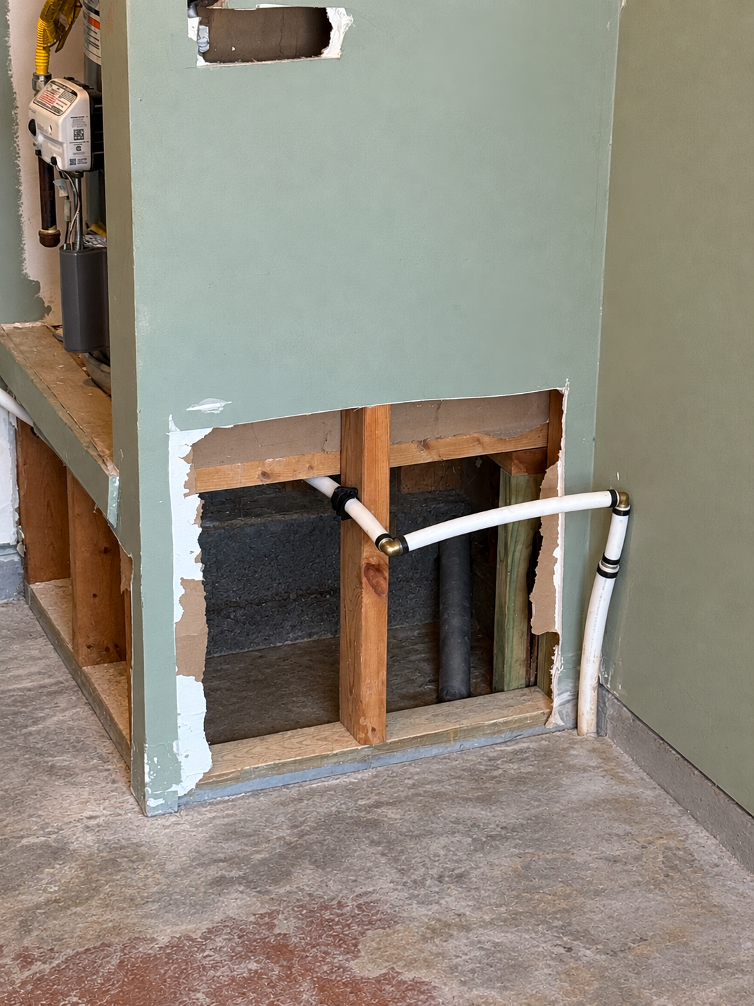 Interior connection — new PEX water line routed through the wall to the home