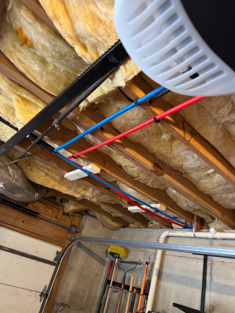 New PEX-B lines routed through the garage ceiling joists