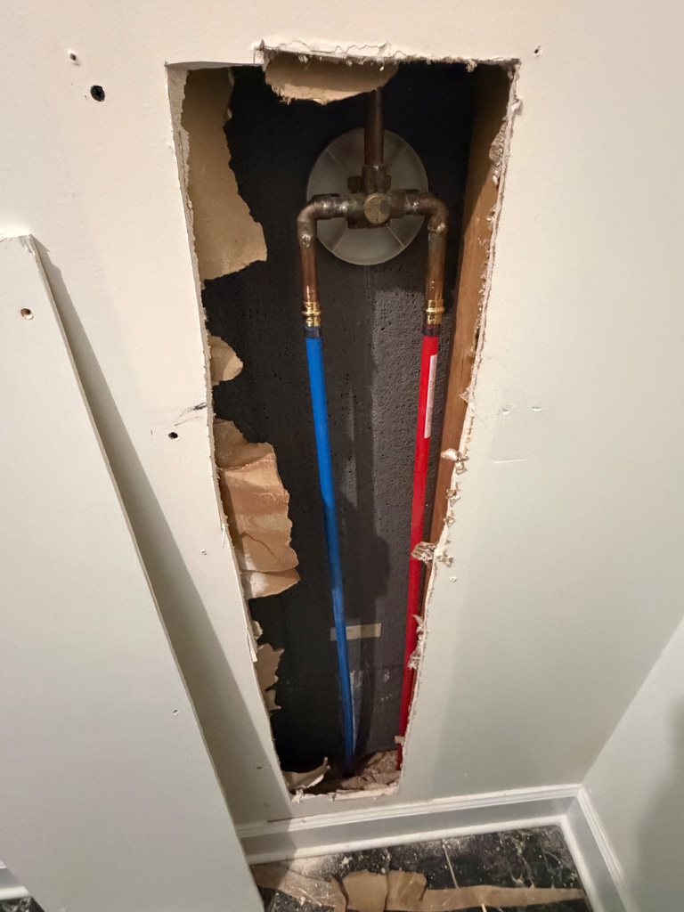 Wall cavity repipe feeding the shower mixing valve