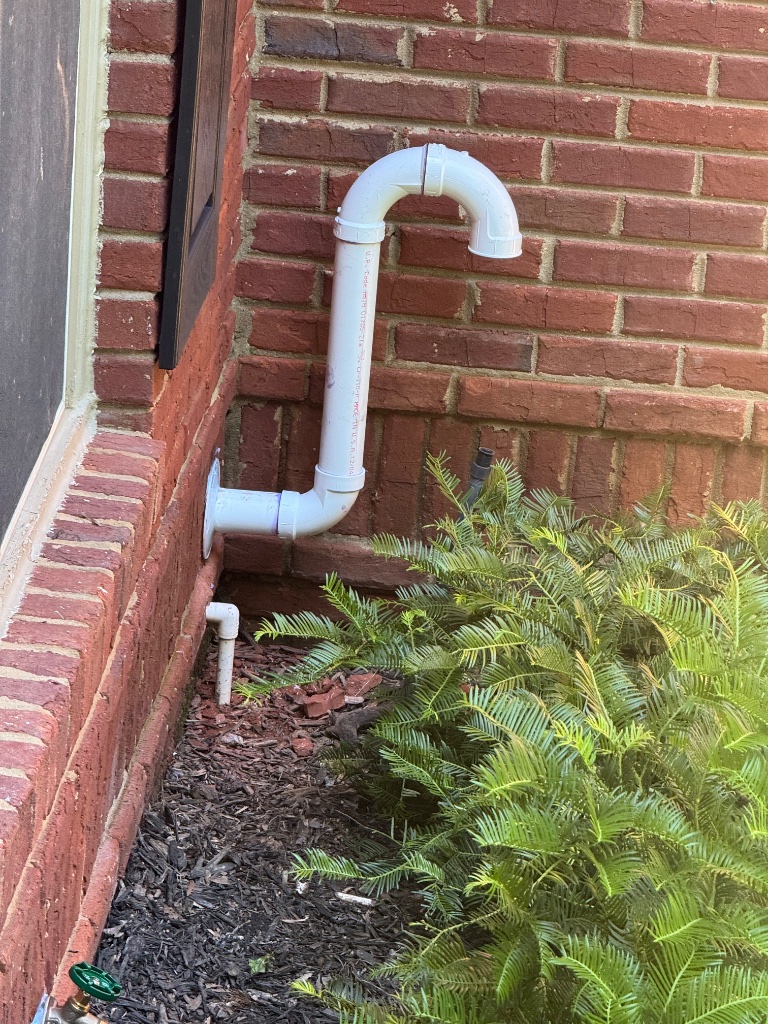 New PVC exhaust vent routed through the exterior brick wall