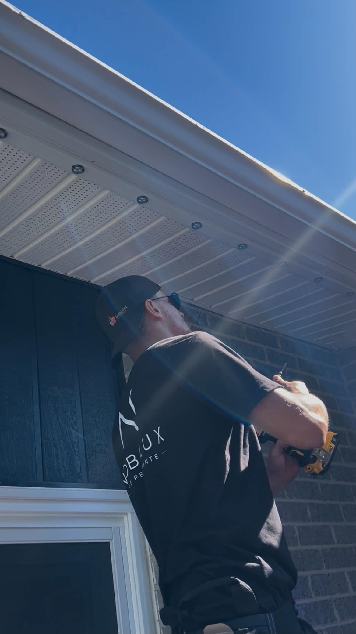 Technicien Nobilux installant un système LED permanent sur un soffit