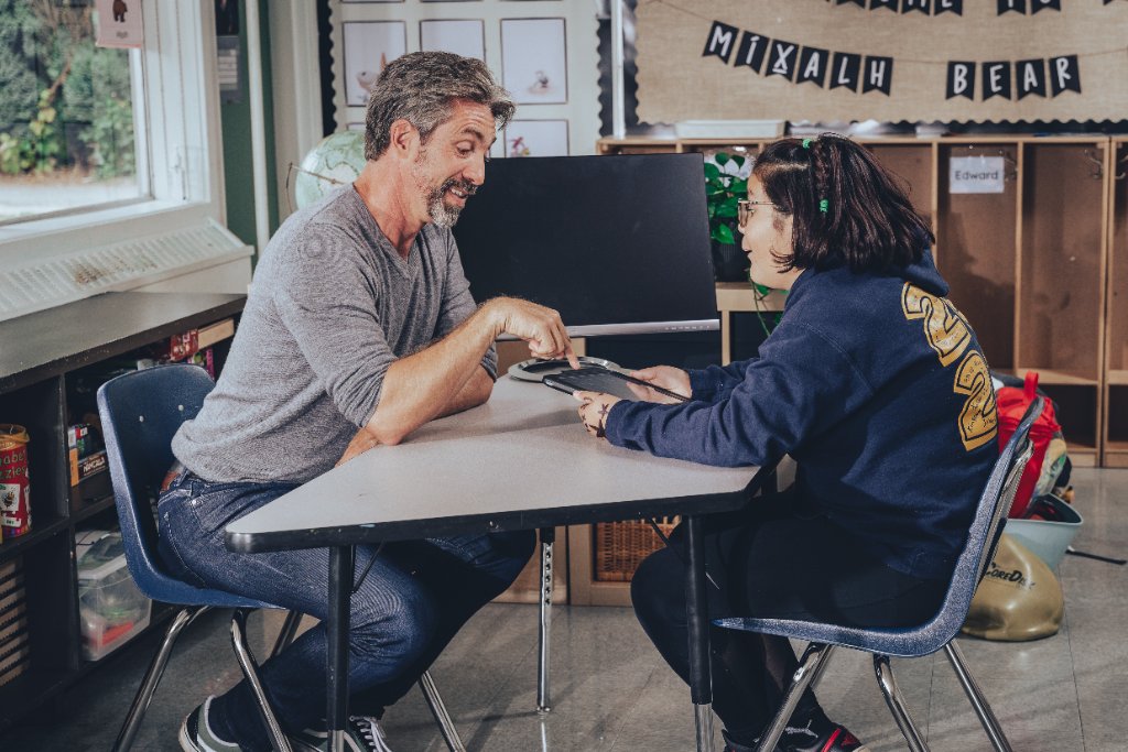 James Burden engaged in focused one-on-one interaction with a student, reflecting personalized family consultation