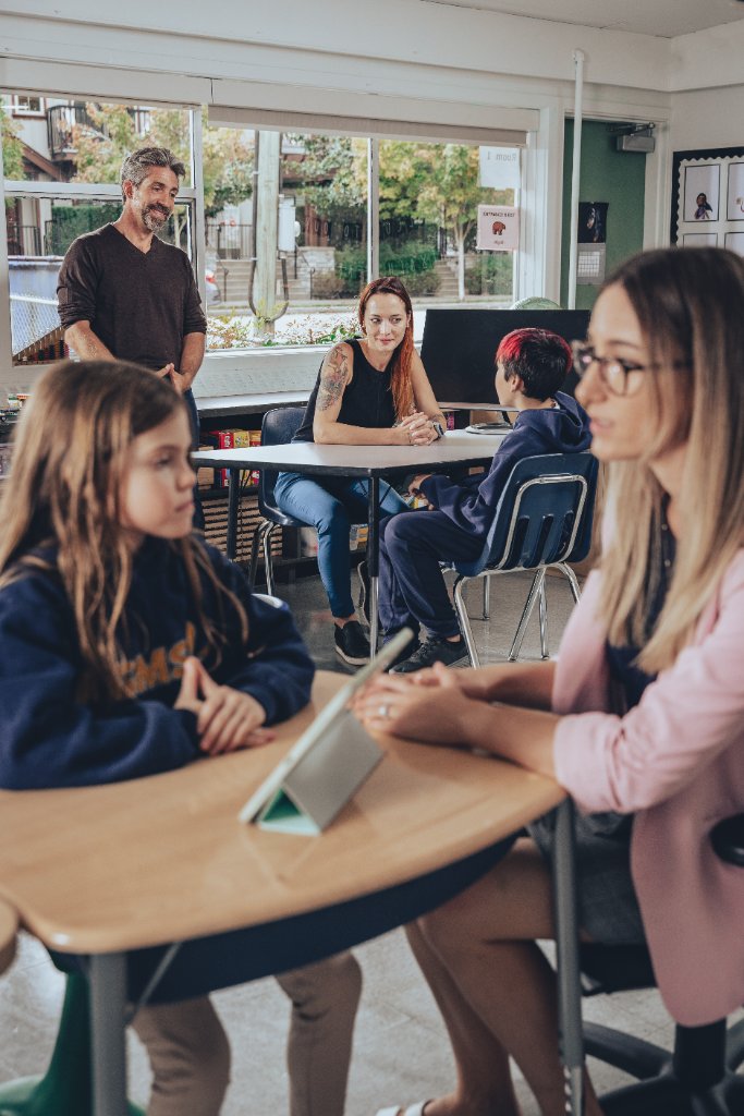 James Burden collaborating with teaching staff in a classroom, demonstrating school-wide consultation