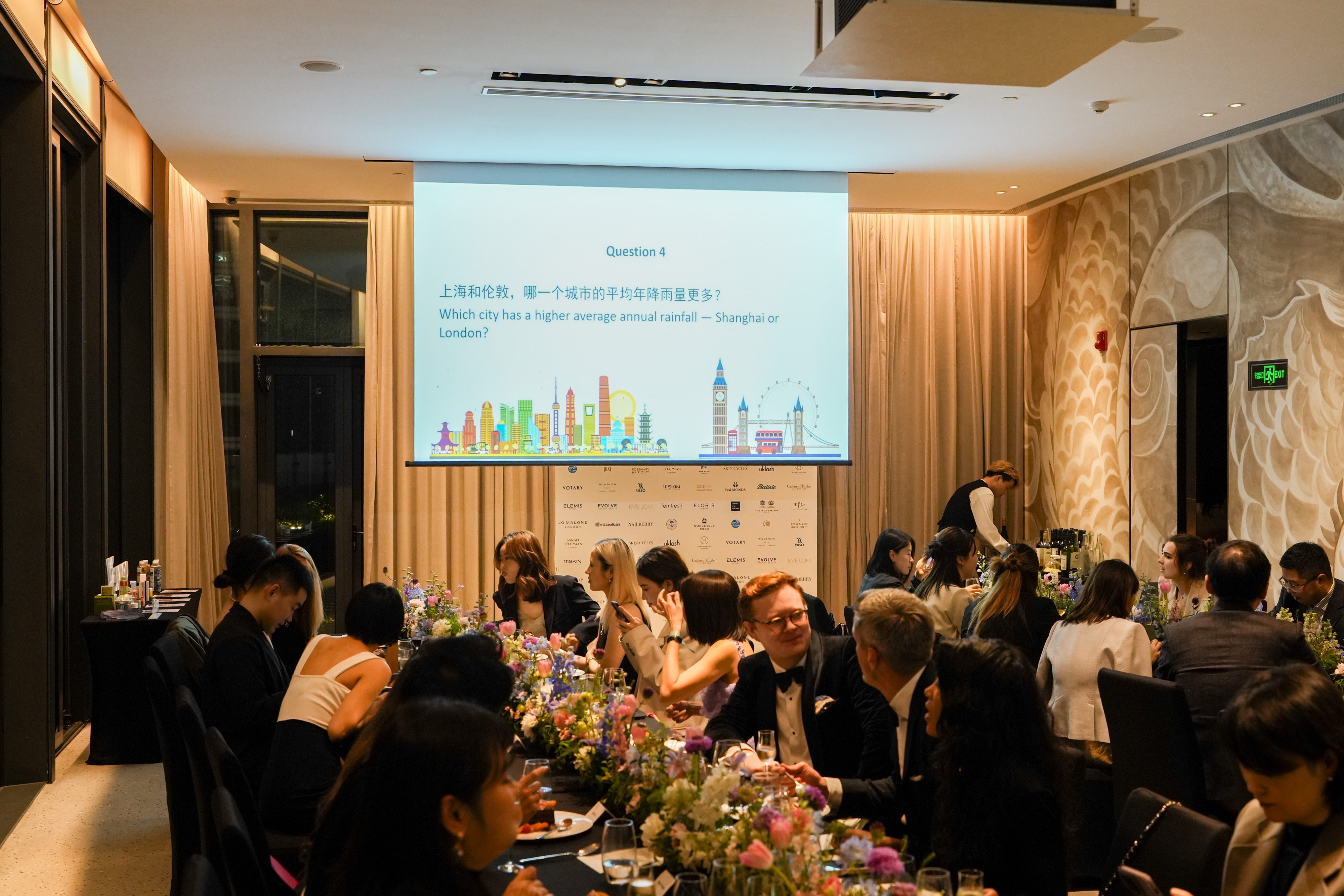 A bilingual quiz between courses, played out against the brand wall.