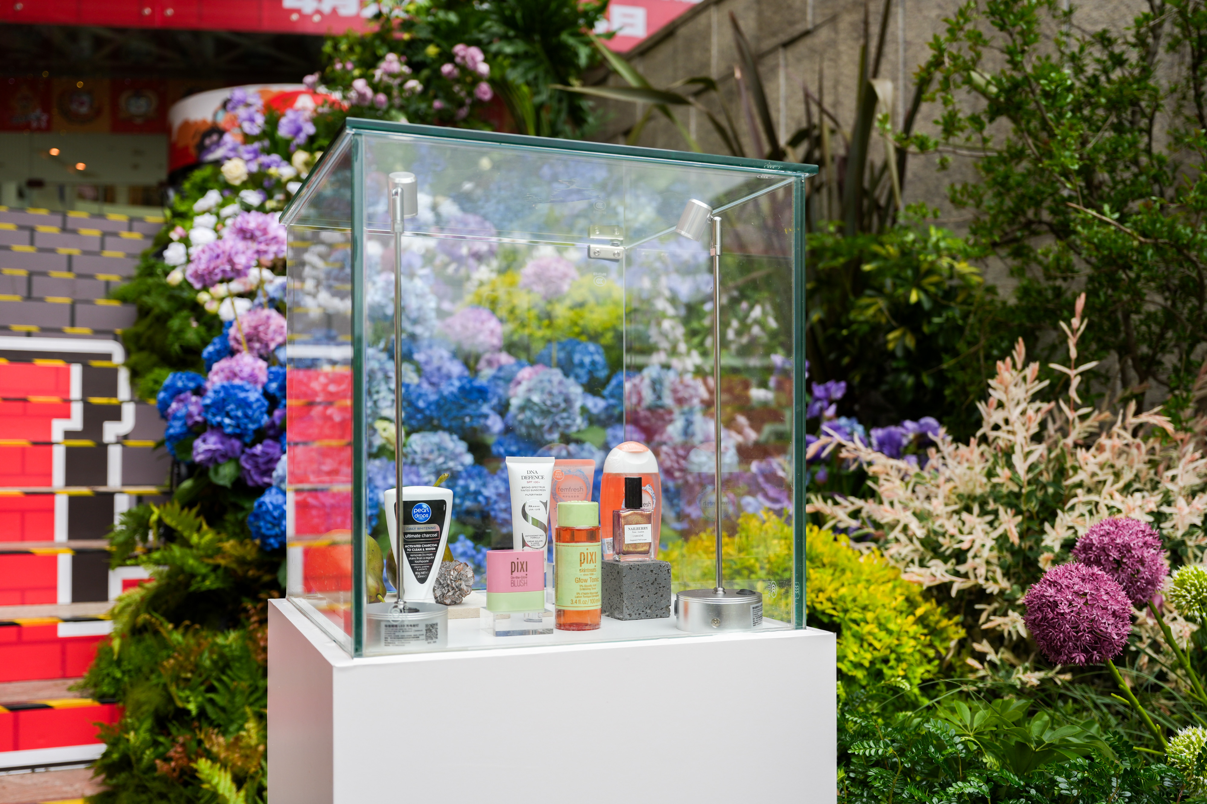 A second vitrine, framed by hydrangea and allium.