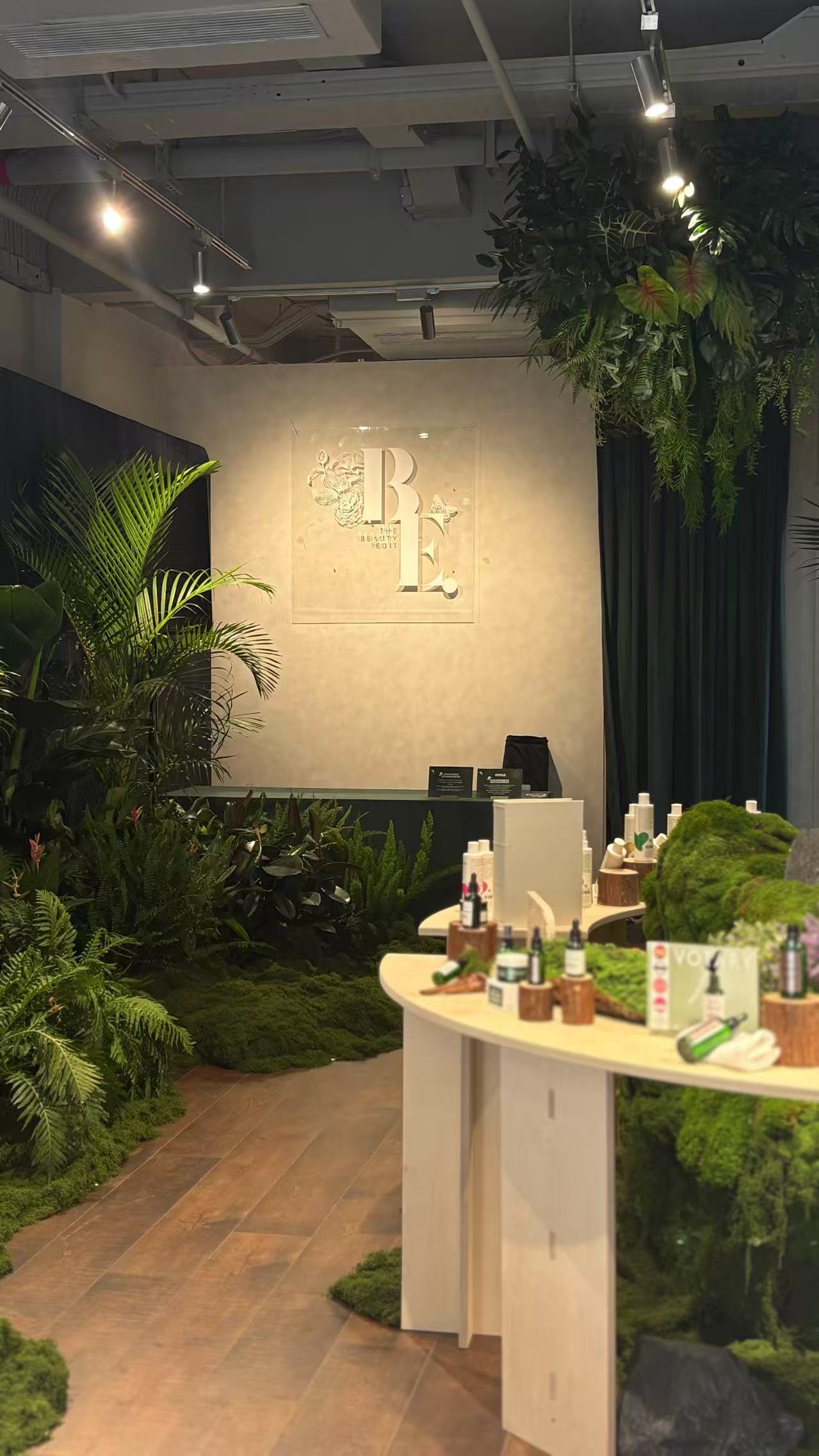 The salon interior looking towards the monogram wall, moss underfoot and foliage overhead