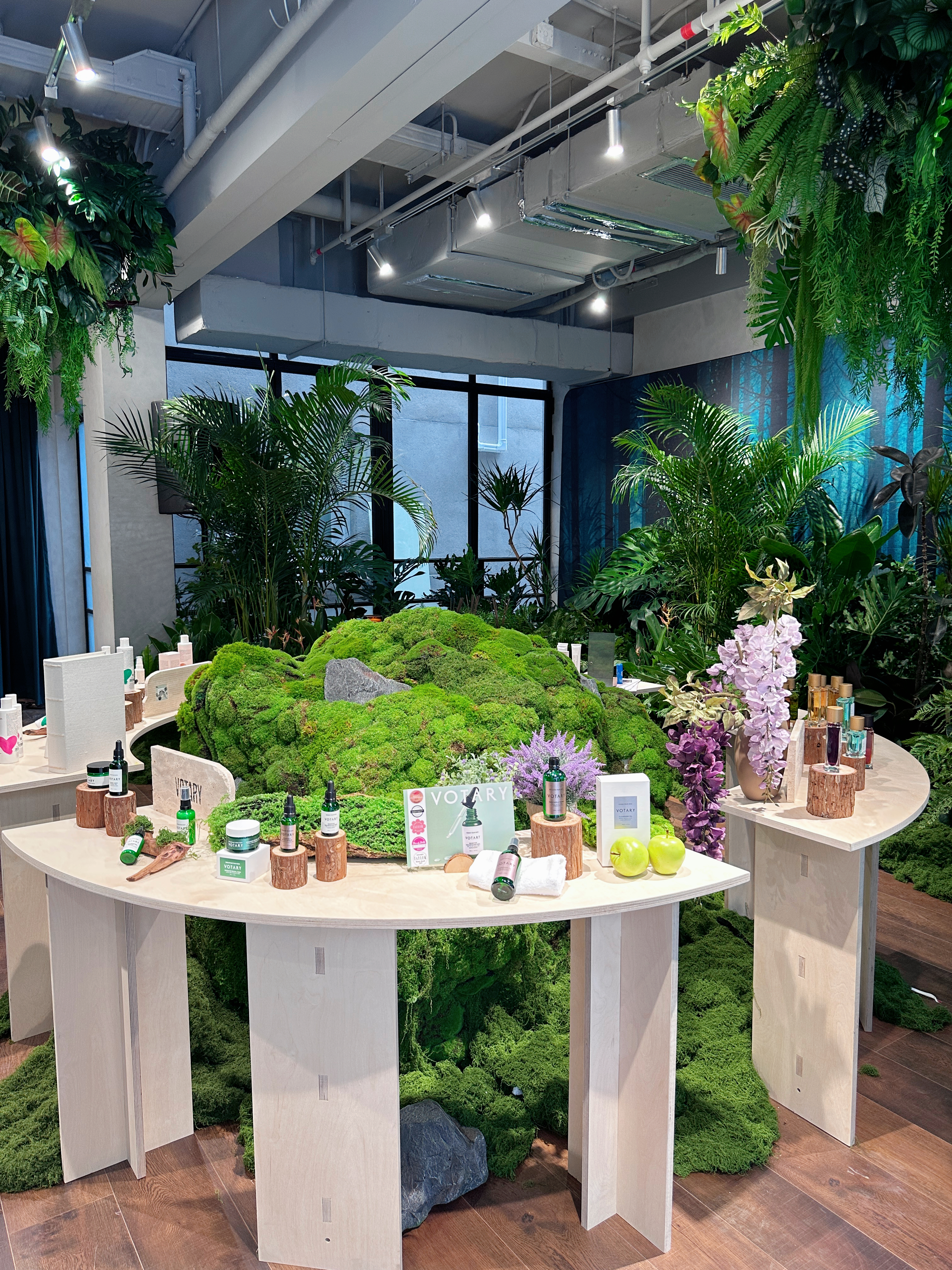 Bespoke birch plinths set into a moss landscape at the centre of the salon