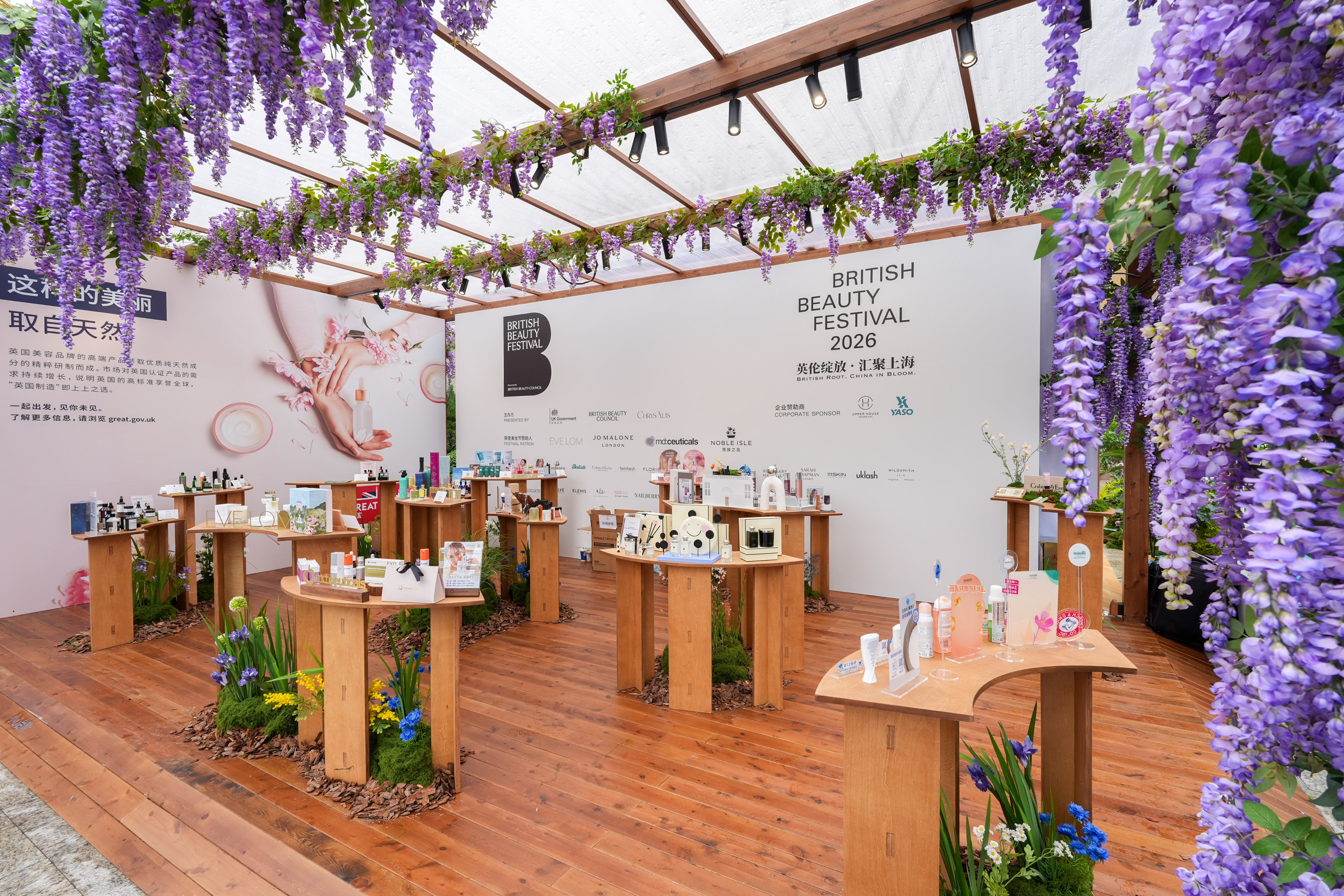 Inside the pavilion, wisteria overhead and brands on plinths of birch.