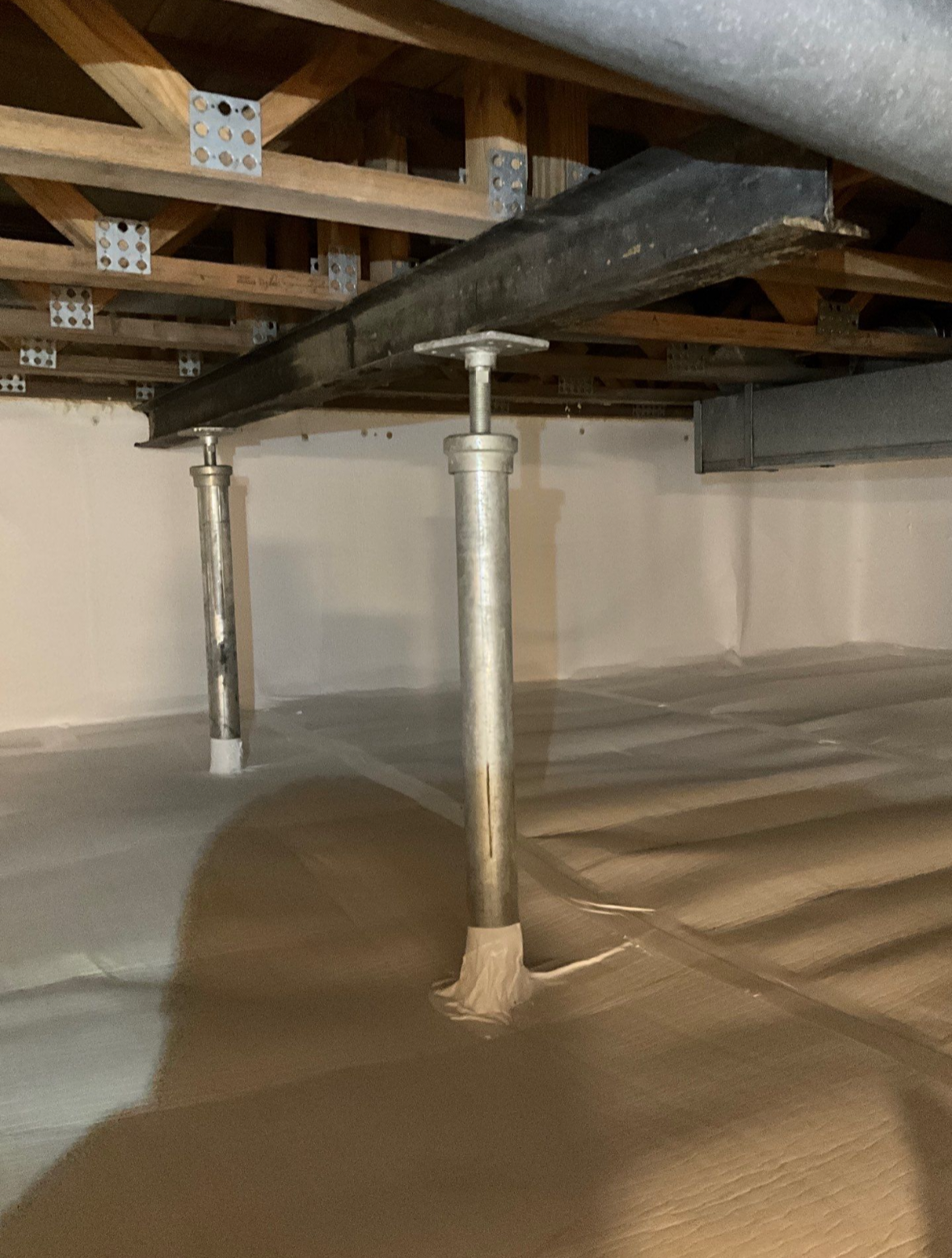 Floor support installation in Murfreesboro, TN — steel support columns bracing an I-beam beneath floor joists by The Crawl Shield