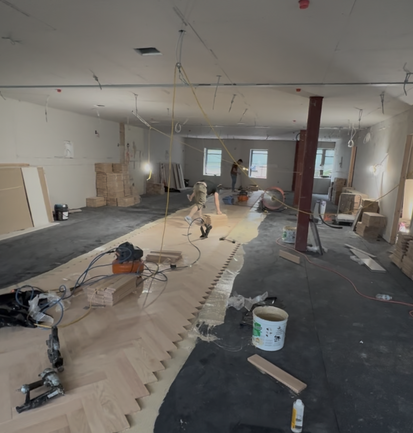 Kiri Construction crew installing a herringbone floor over a prepared underlayment across an open restaurant space at the Seafire Grill 49th Street location in NYC
