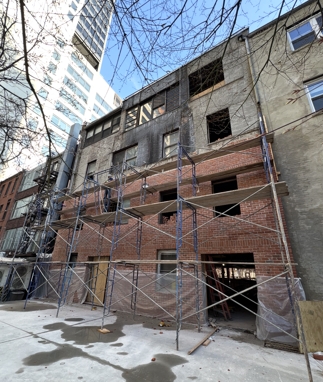 Fire-damaged rear facade being rebuilt with new red brick from scaffolding at the Seafire Grill 49th Street location in New York City
