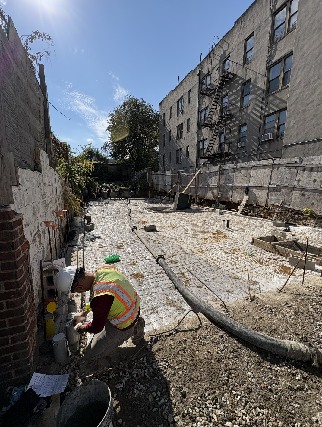 Steel rebar mesh and vapor barrier laid over a gravel base before a concrete slab pour on East 216th Street in the Bronx, NY