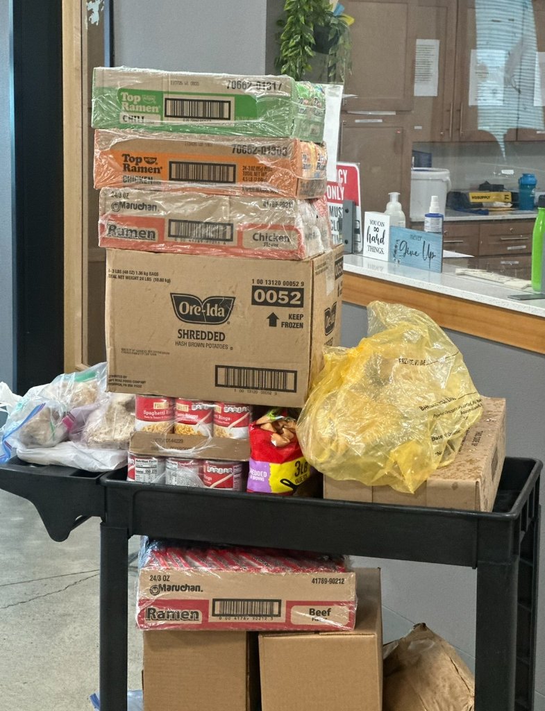 Rolling cart stocked with ramen and food boxes