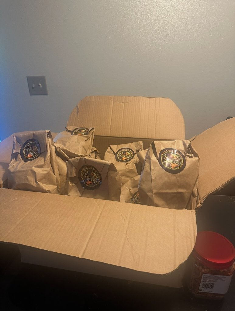 Box of brown paper bags sealed with Alkebulan stickers