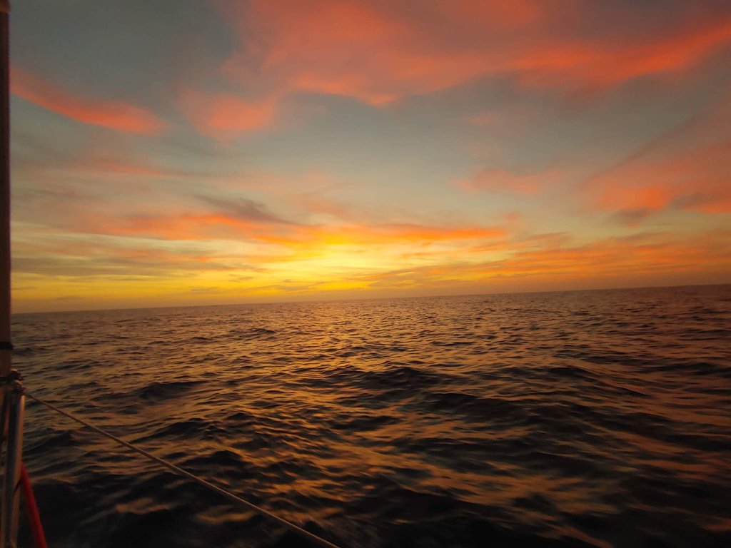Puesta de sol en el mar con velero