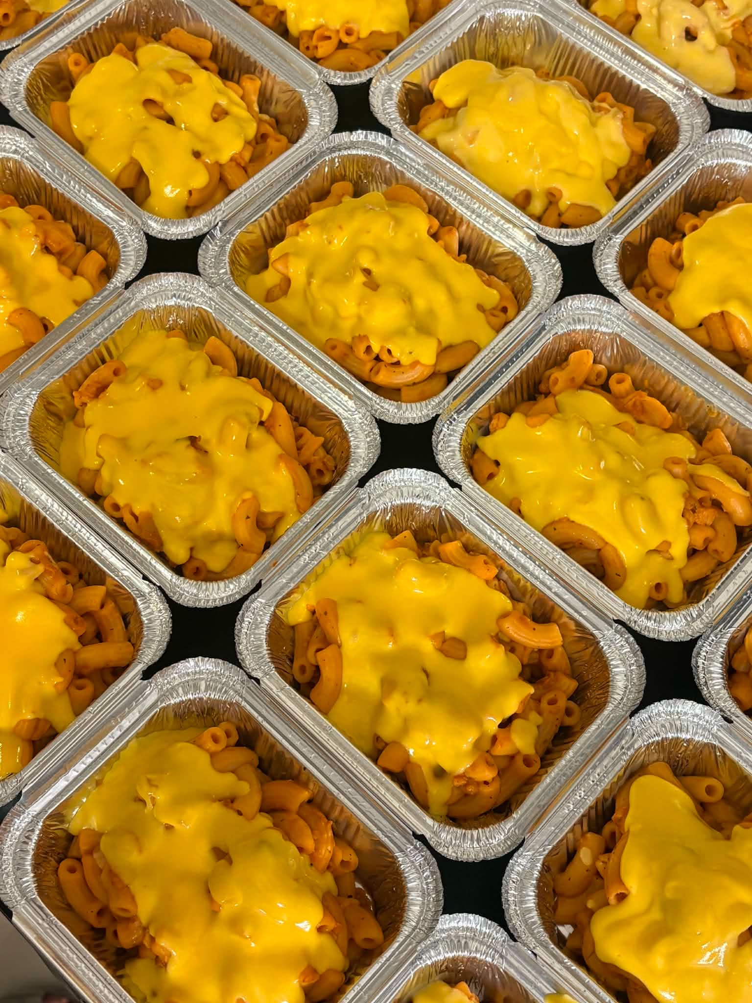 Bulk meal-kit spread of Filipino crew meals in portioned containers