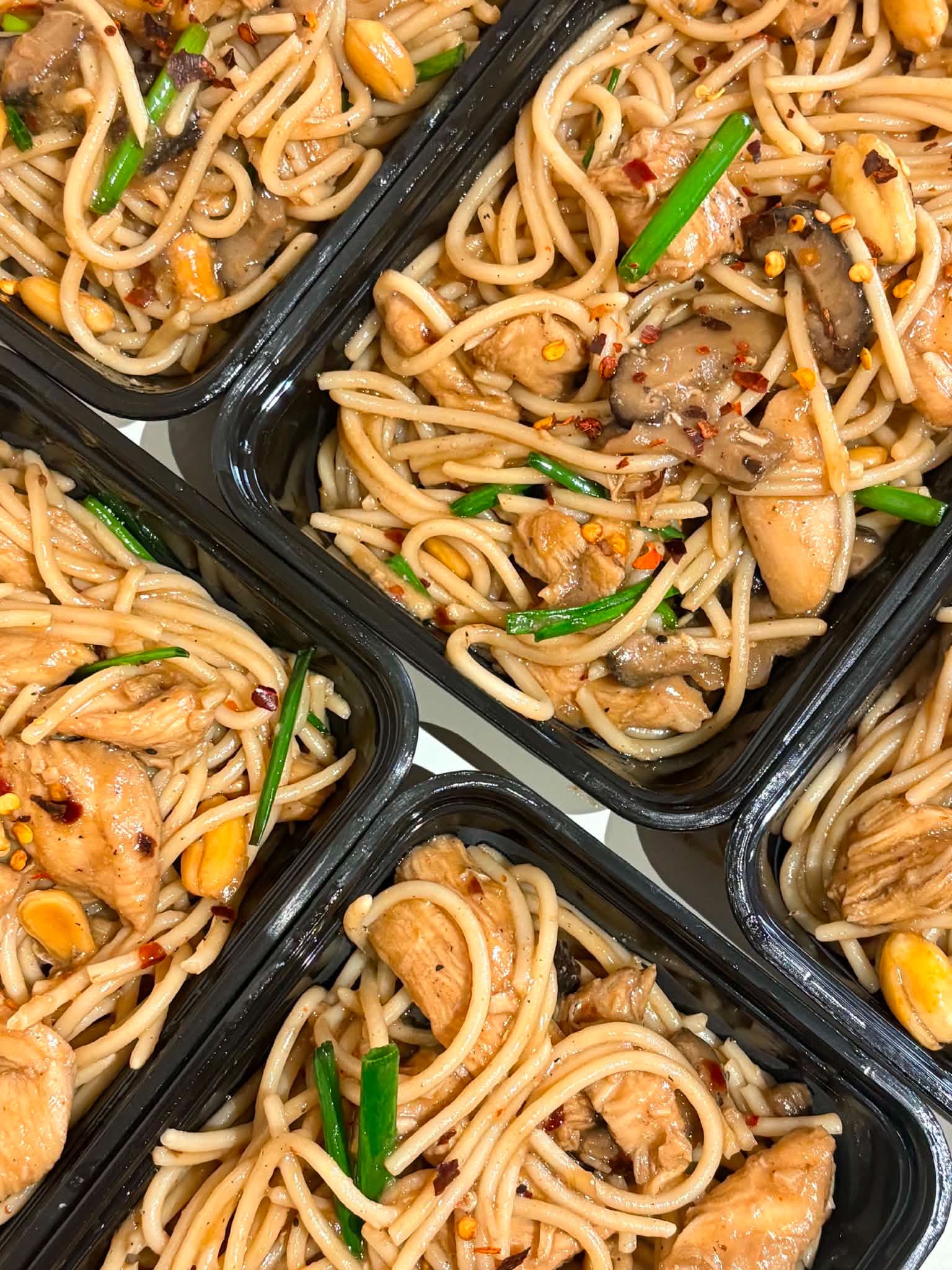 Bulk meal-kit spread of Filipino crew meals in portioned containers