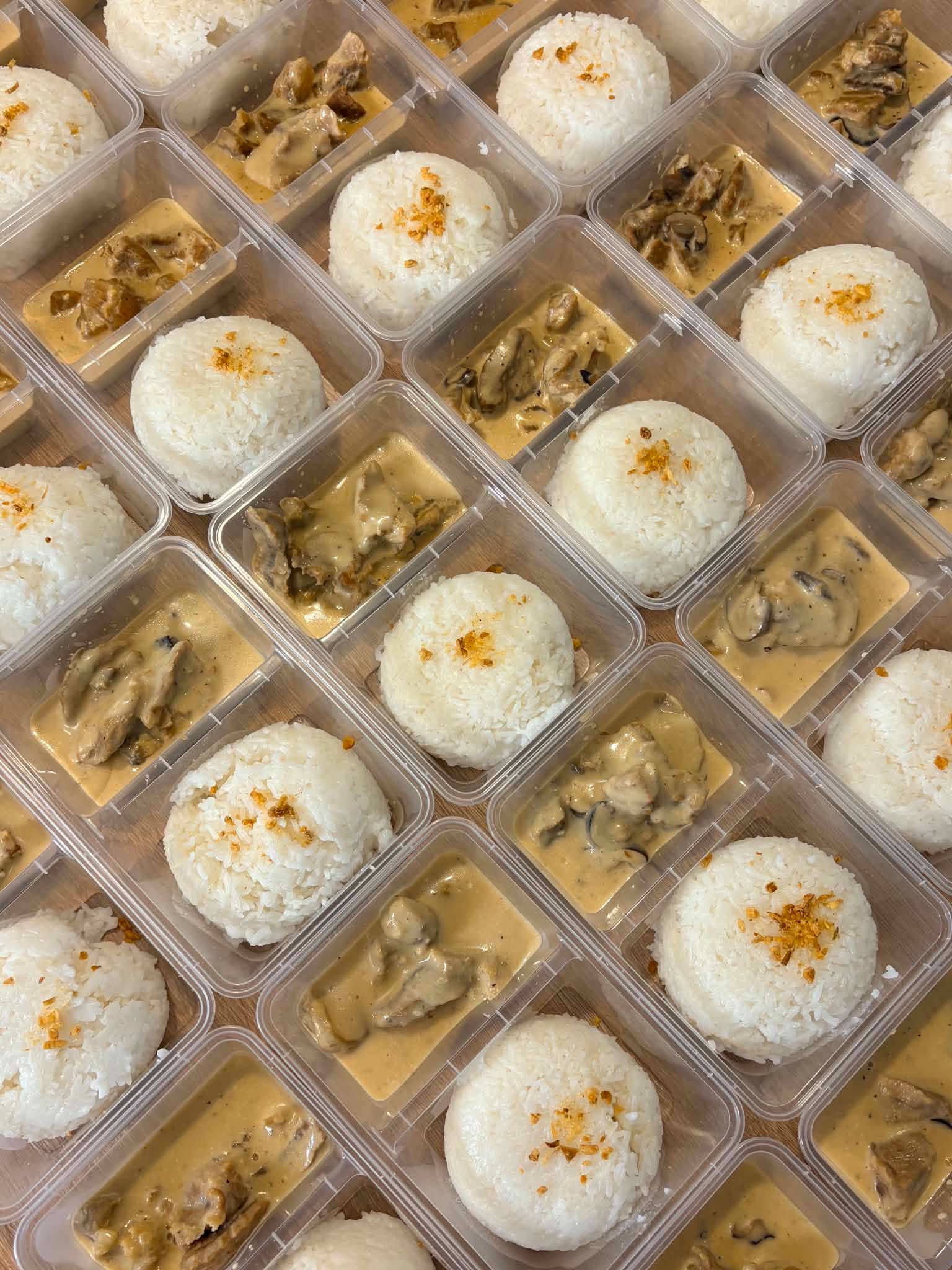 Bulk meal-kit spread of Filipino crew meals in portioned containers