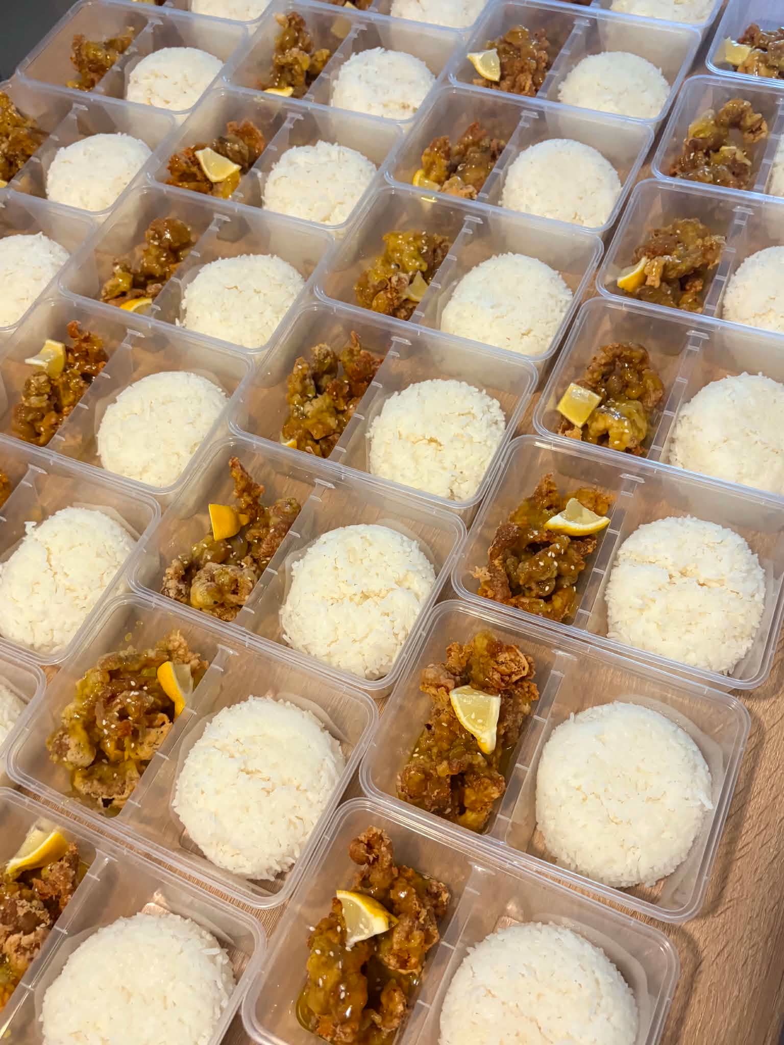 Bulk meal-kit spread of Filipino crew meals in portioned containers