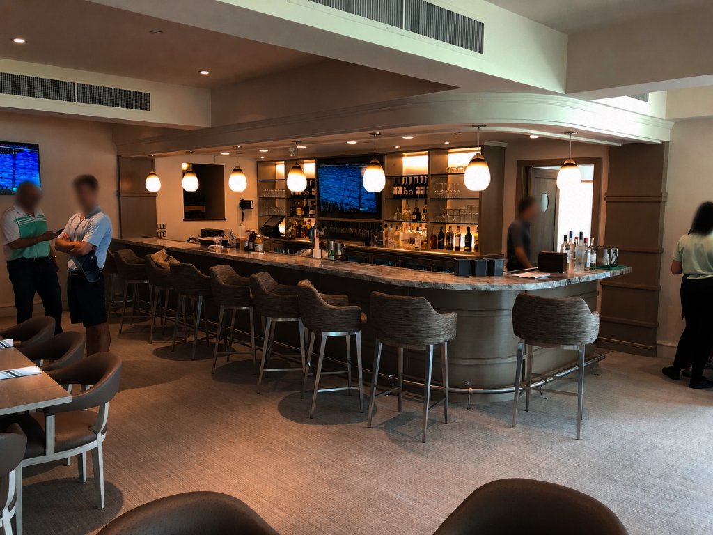 Custom curved bar with marble countertop and pendant lighting