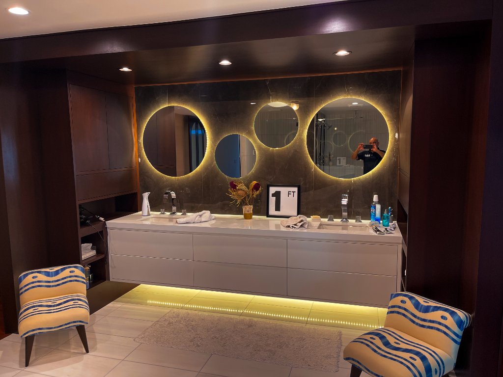Custom double vanity with backlit round mirrors in a spa bathroom