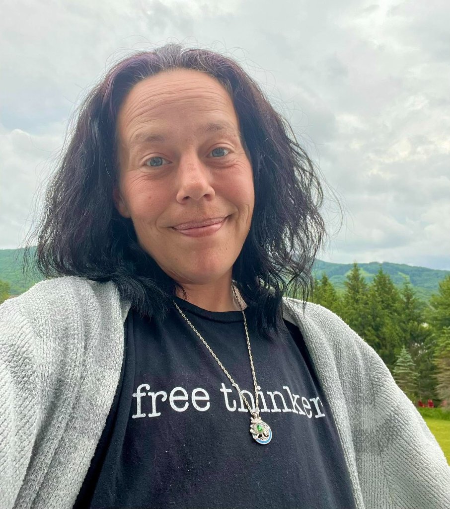 Crystal Butcher smiling confidently outdoors against the backdrop of West Virginia's rolling green hills