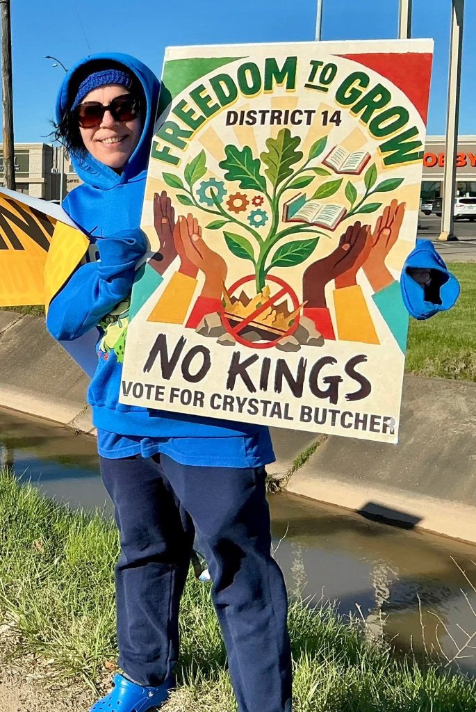 Crystal Butcher holding a Freedom to Grow, No Kings sign outdoors in District 14