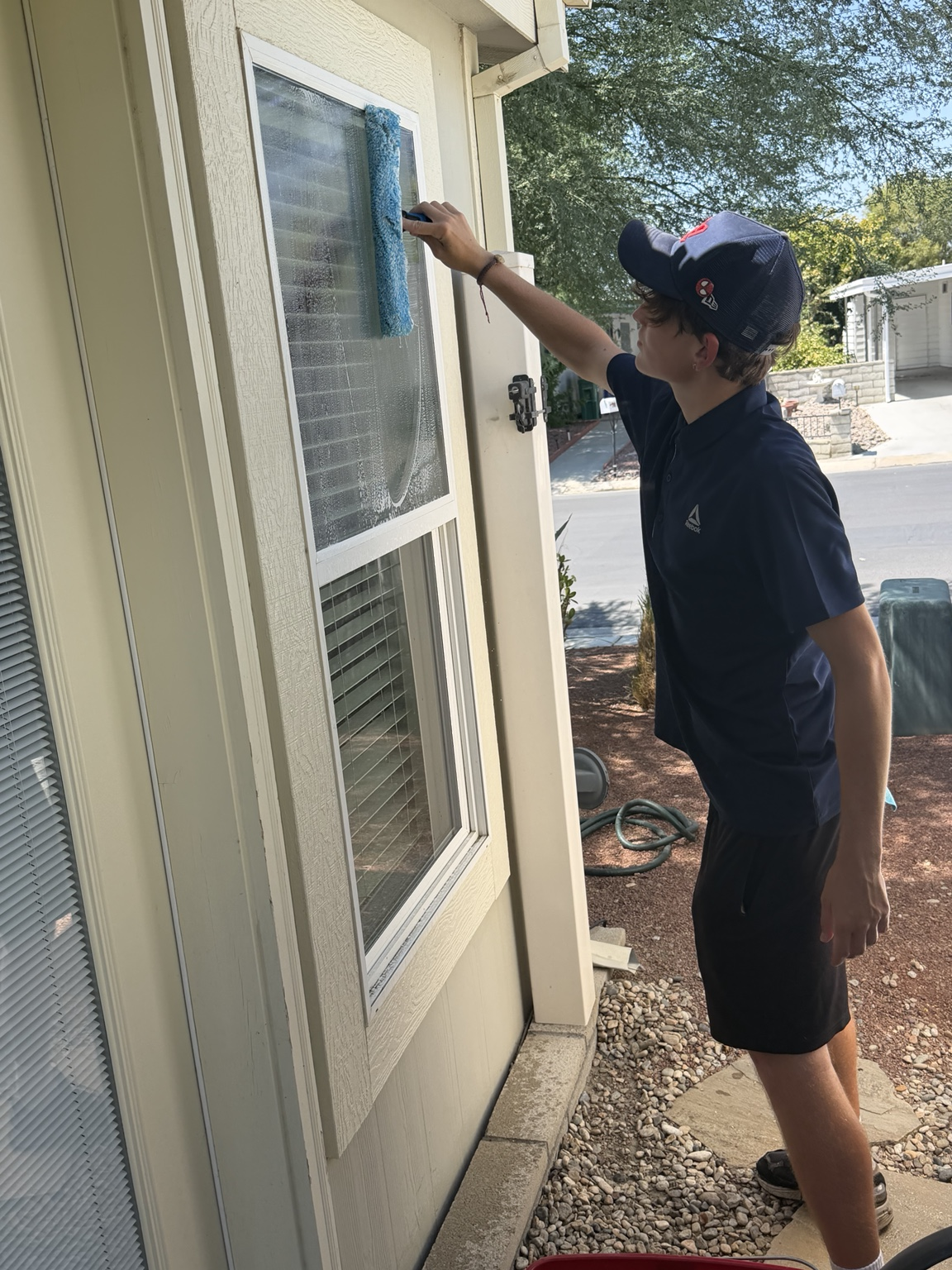 Blue Palm Services team member cleaning a residential window in the Coachella Valley