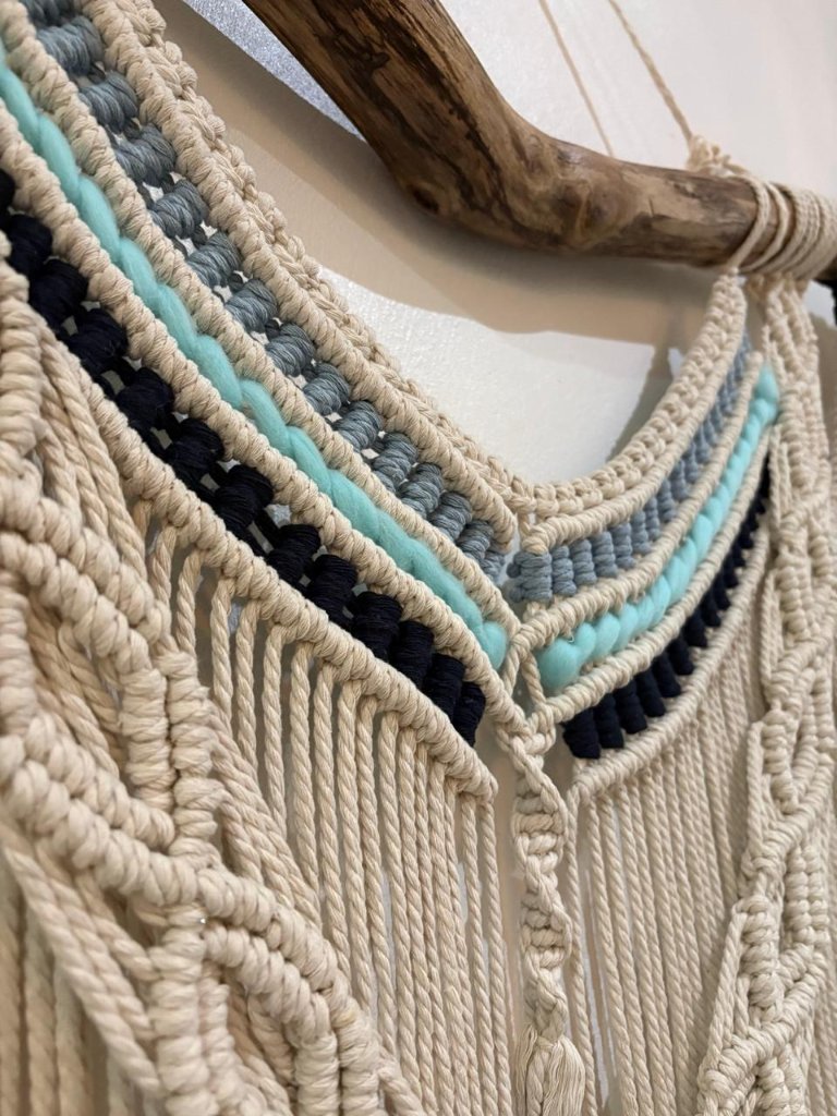 Macramé wall hanging on driftwood with teal, charcoal and blue-grey accents