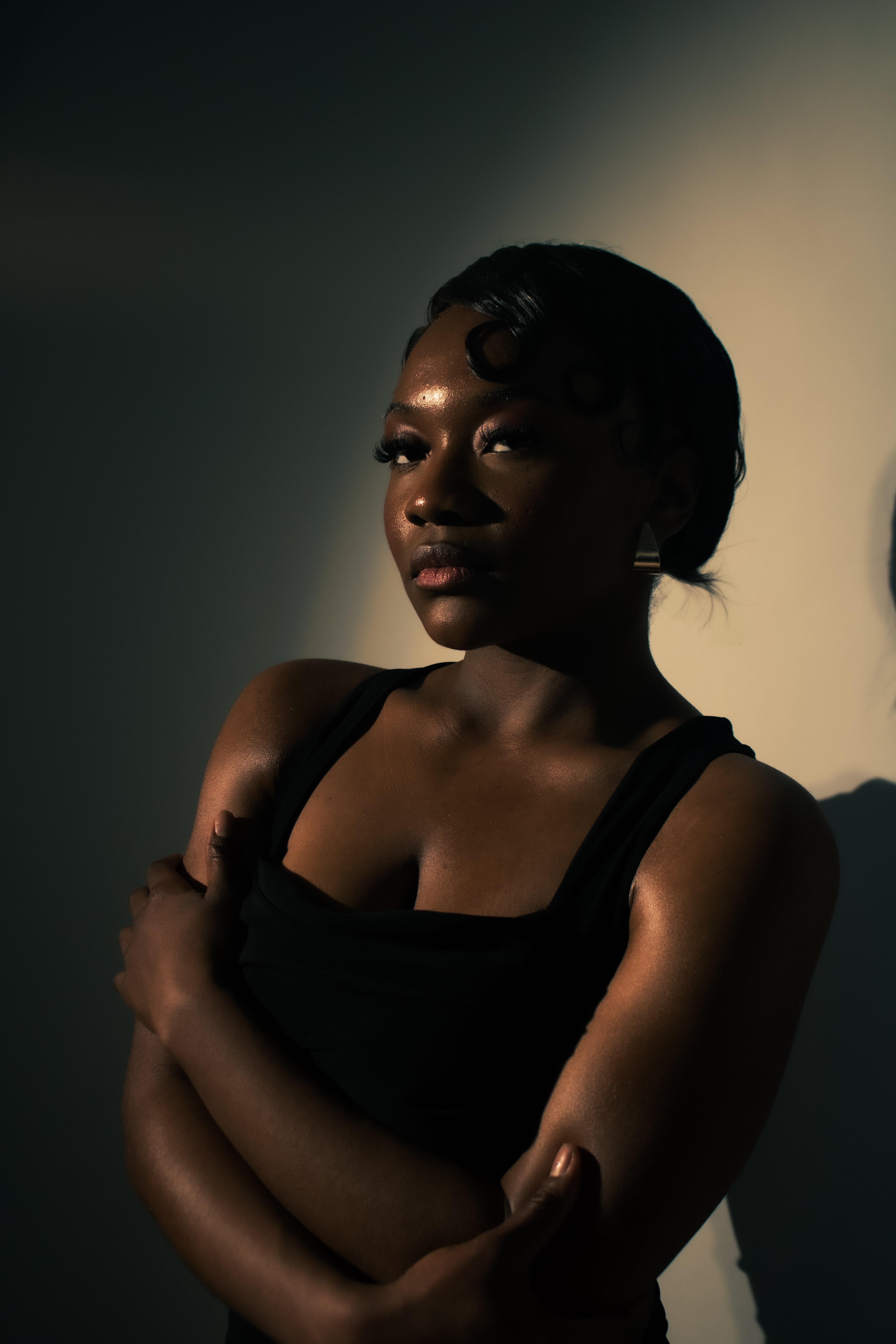 Studio portrait, woman in dramatic lighting, arms crossed