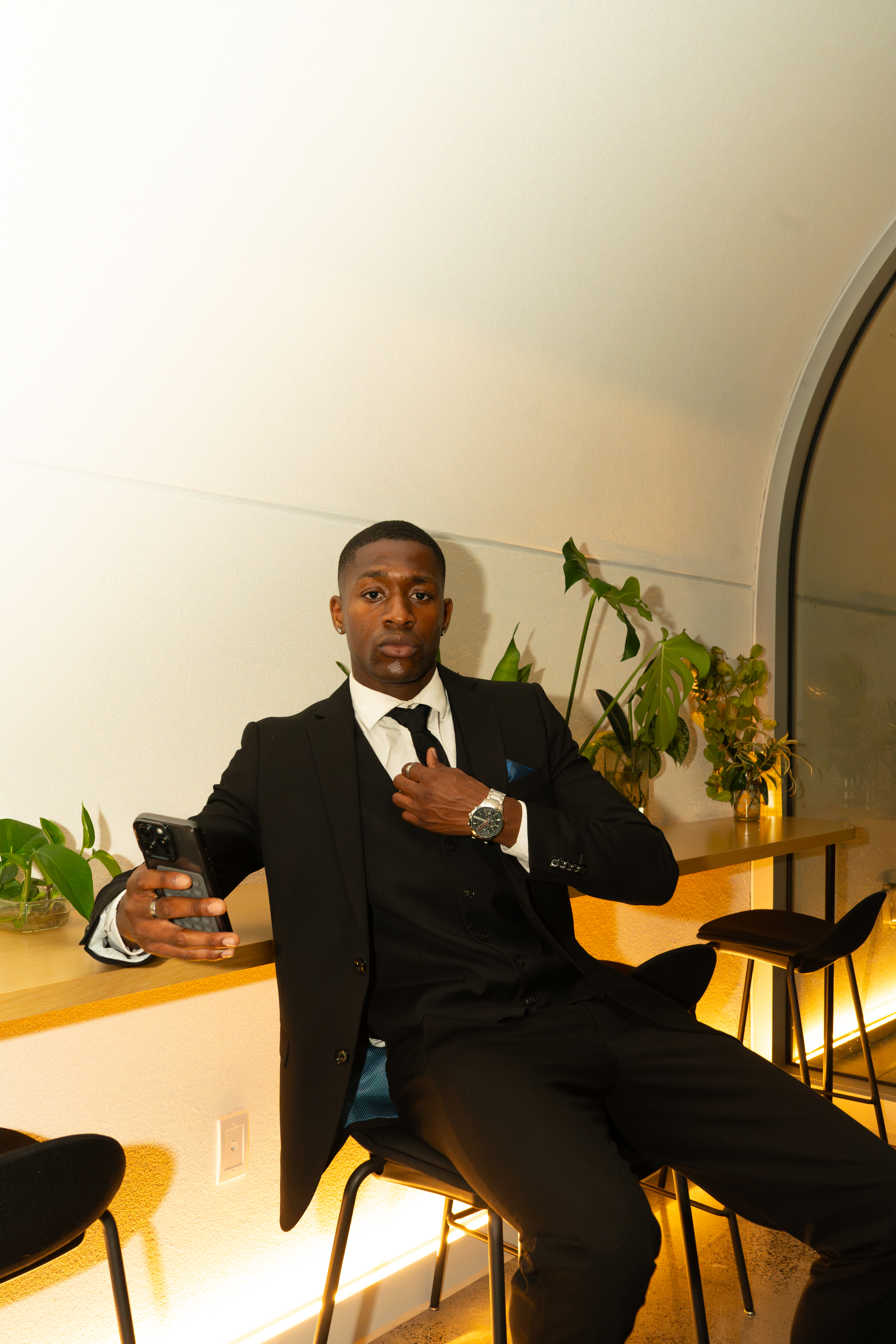 Man in black suit, warm interior