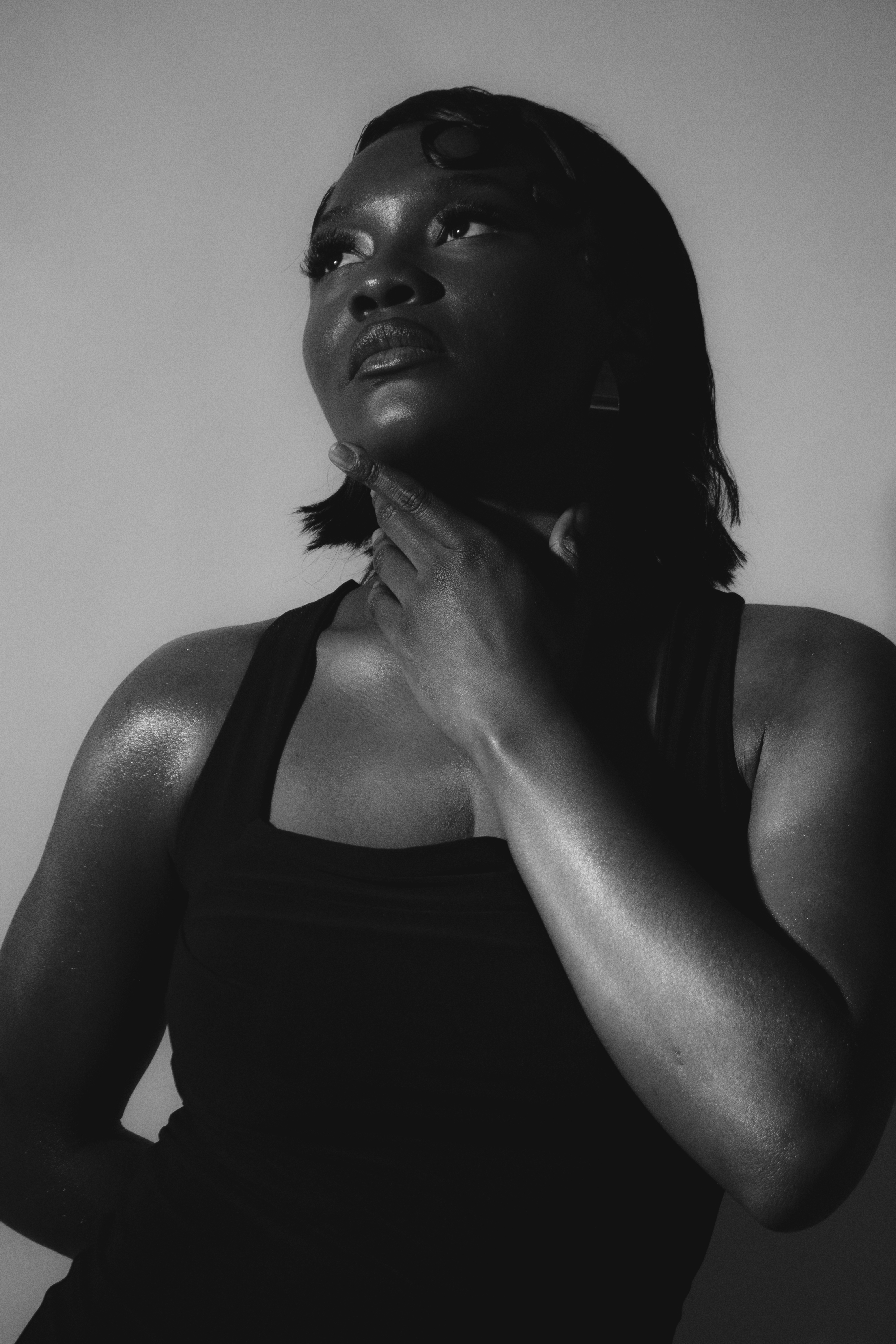 Black and white studio portrait, hand on chin