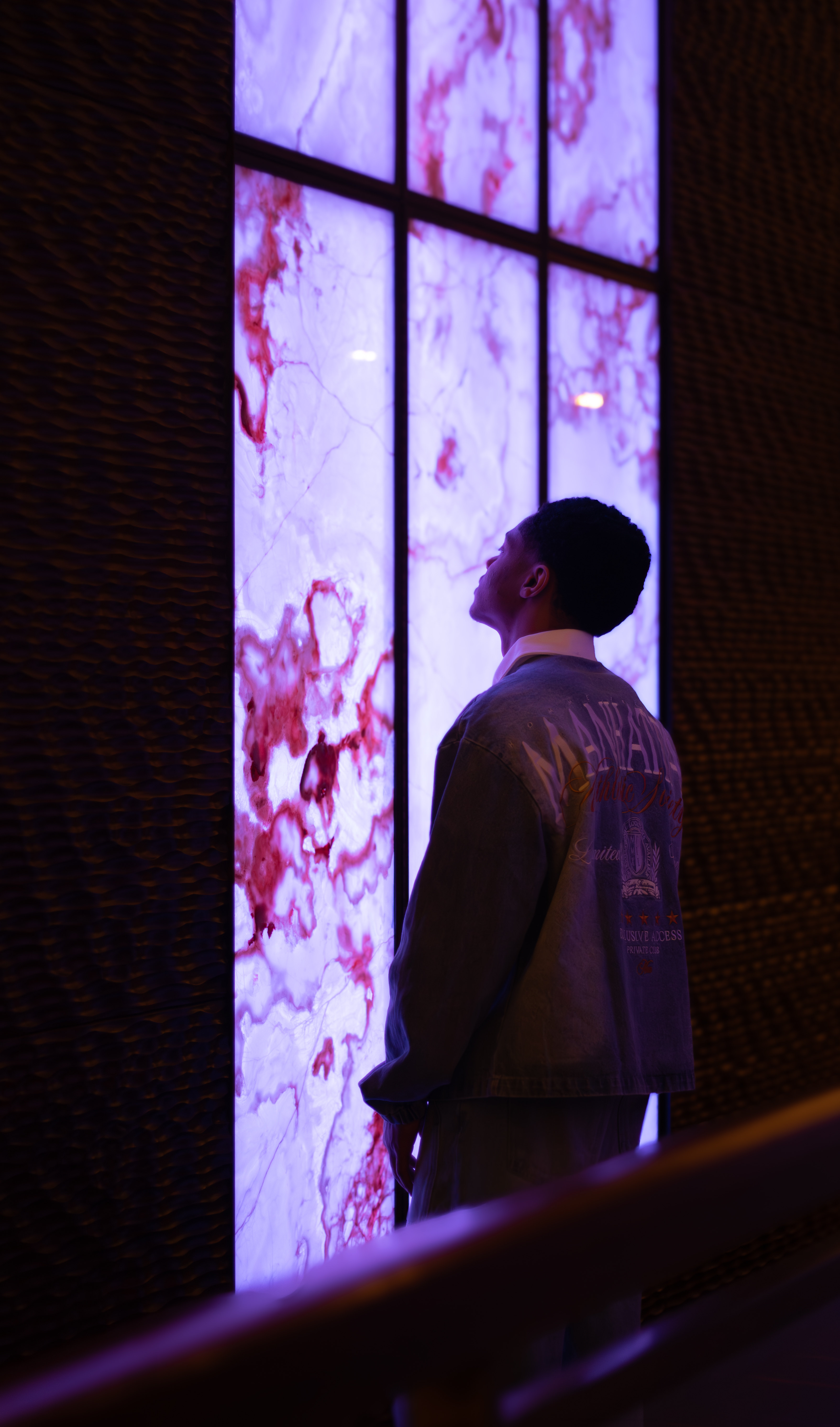 Editorial, man in profile, backlit purple wall