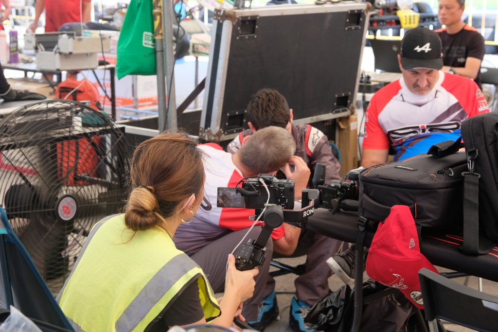 Aira filming a documentary on a Ronin gimbal at a racing paddock