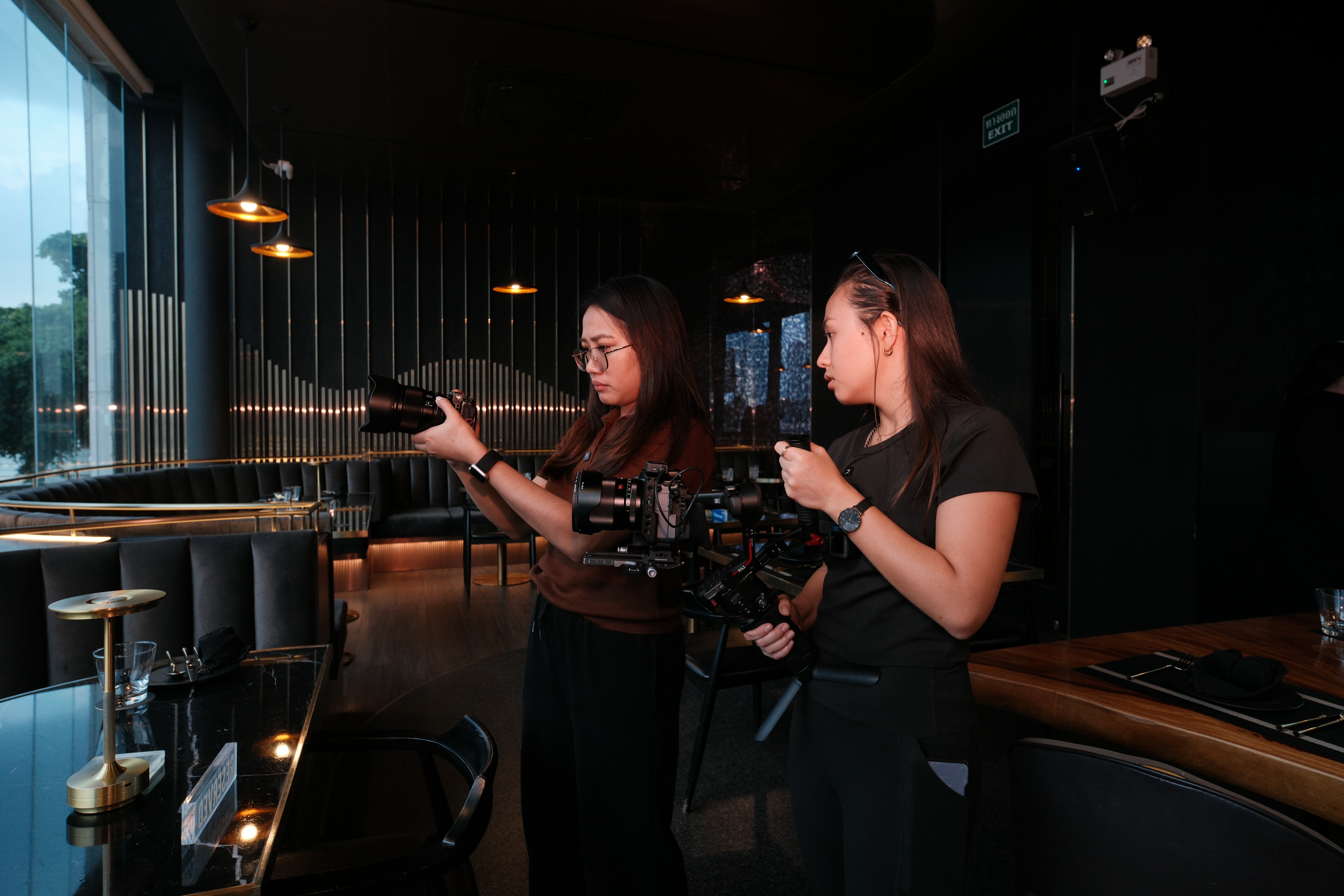 Two videographers preparing camera equipment at Osca & Blanco